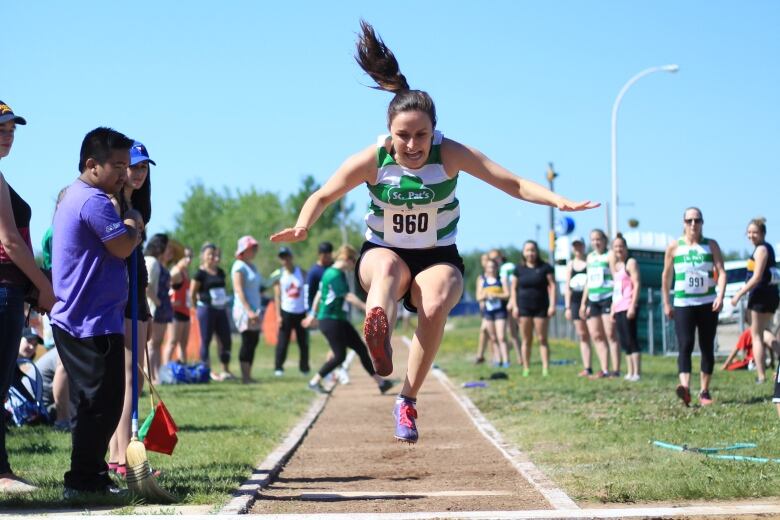 A young girl competes in long jump at a track and field meet