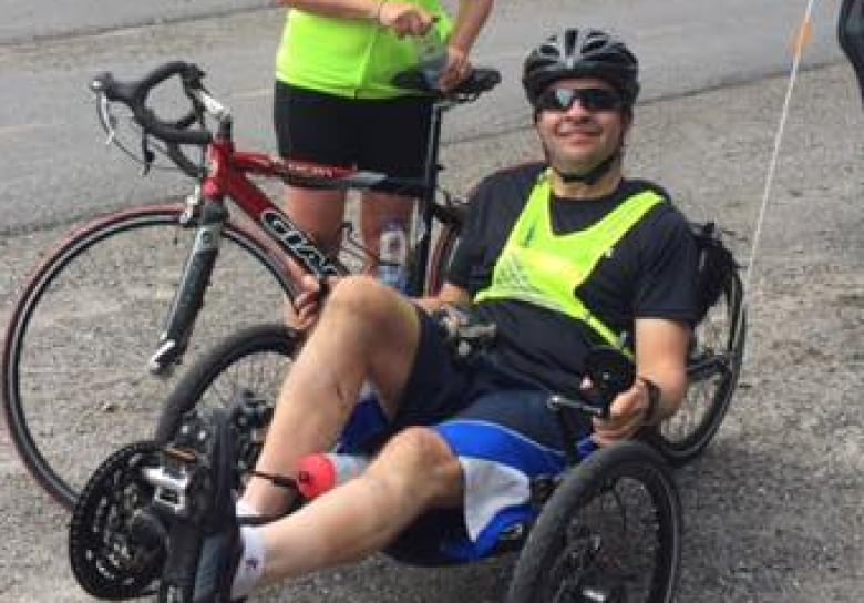 A man on a recumbent bike with a woman on a bike.