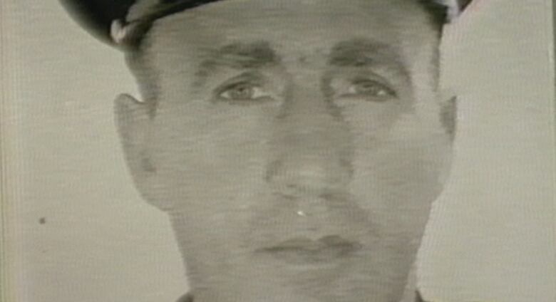 A police officer is shown in a black and white photo. It's a headshot.