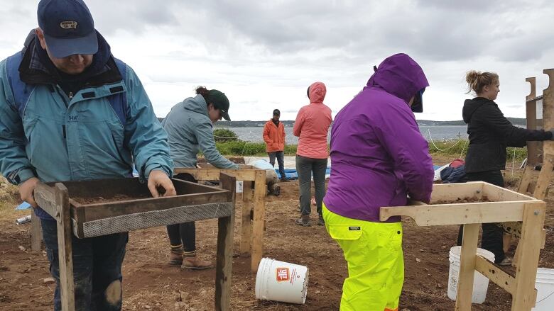 Archaeology students work to save 19th-century graves from coastal erosion at the fortress of Louisbourg in 2017.