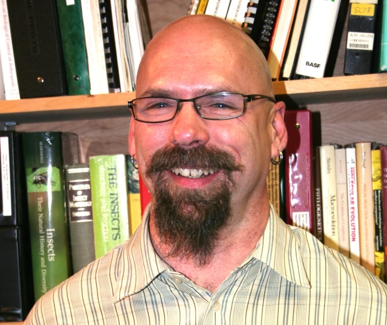 A man with glasses and a goatee smiles for the camera.