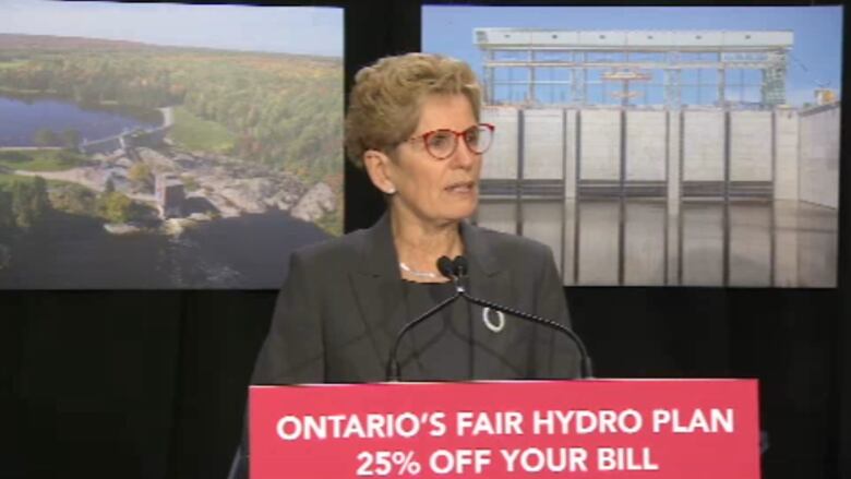 Kathleen Wynne stands at a podium that reads 