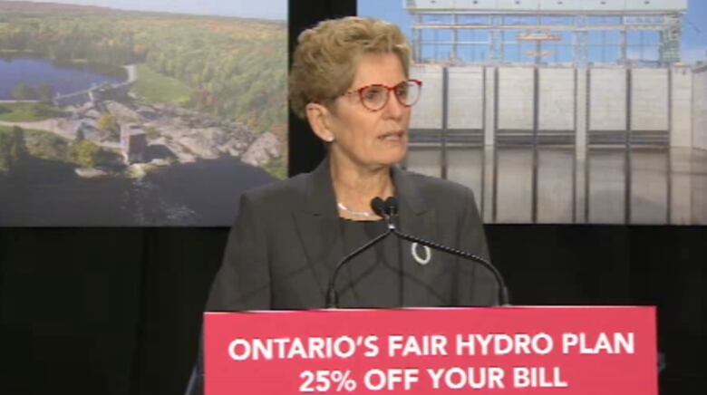 Kathleen Wynne stands at a podium that reads 