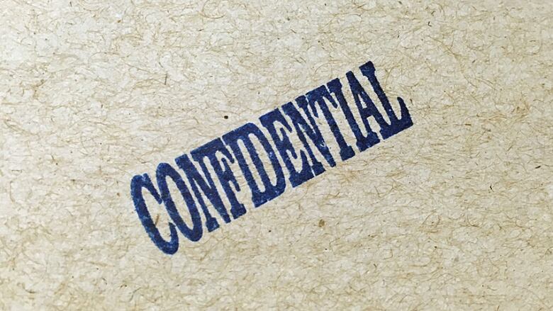 A blue CONFIDENTIAL stamp is on a brown envelope.