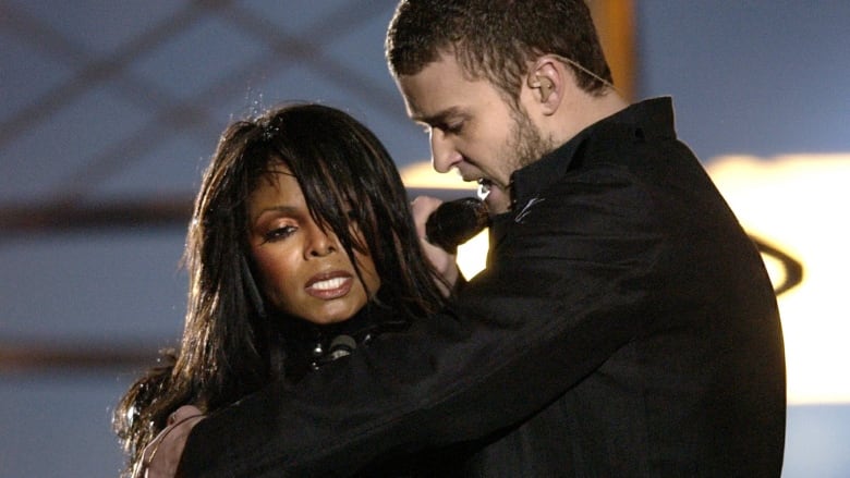 A woman and a man sing on a stage