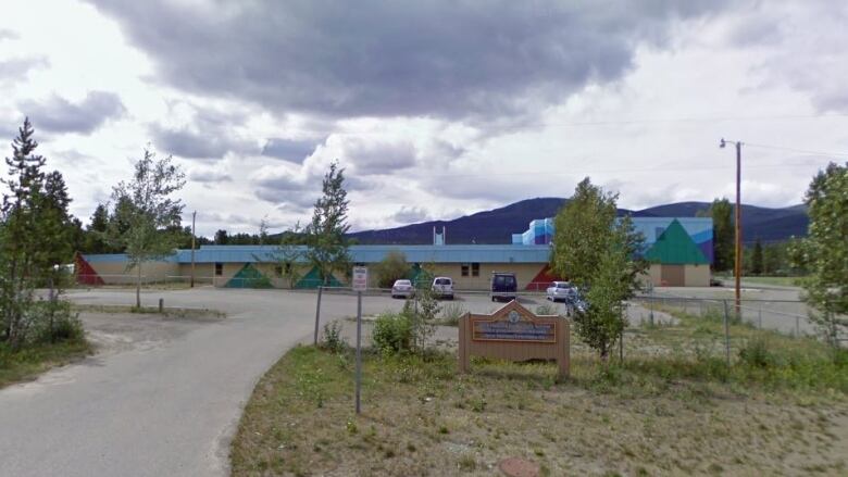 The photo shows the front of an elementary school surrounded by trees.