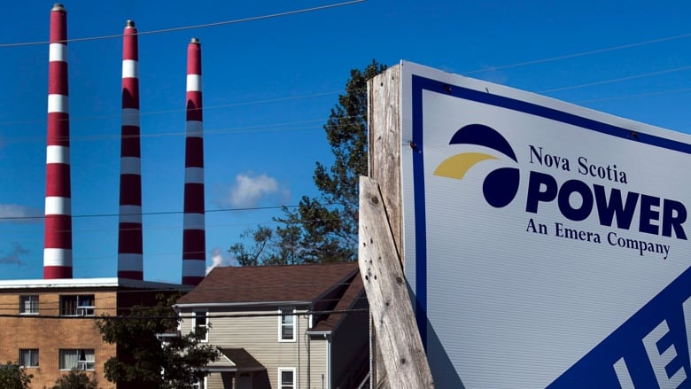 A Nova Scotia Power sign is shown in the foreground. In background are houses and the Tufts Cove generating station stacks.