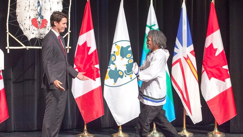 Justin Trudeau welcoming Toby Obed to a stage.