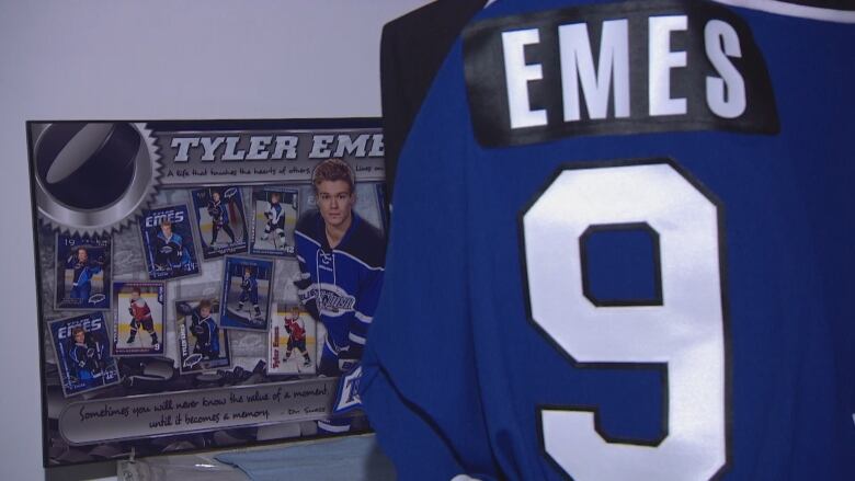 A jersey with Emes and #9 is shown in front of a memorial.