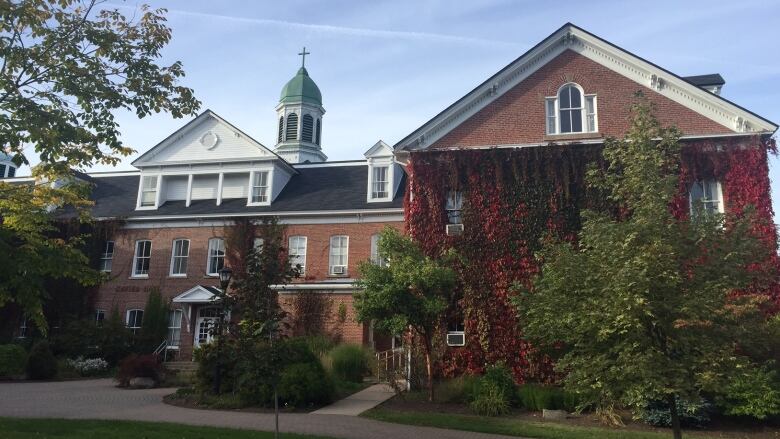 Photo of red brick building with white roof.