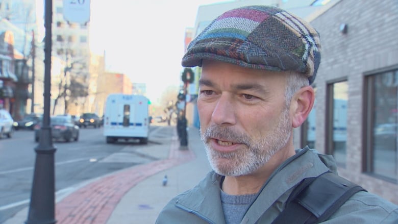 A man speaks while standing up in downtown Fredericton.