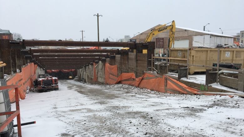 A construction site showing the sloping entrance down into a tunnel.