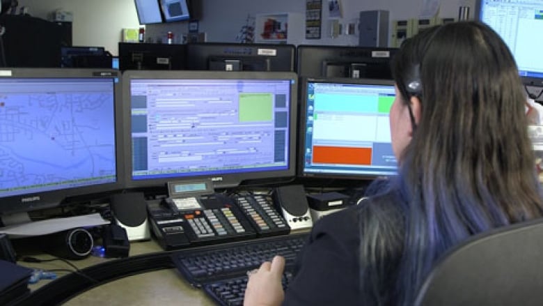 A person looks at a series of screens in an emergency dispatch centre.