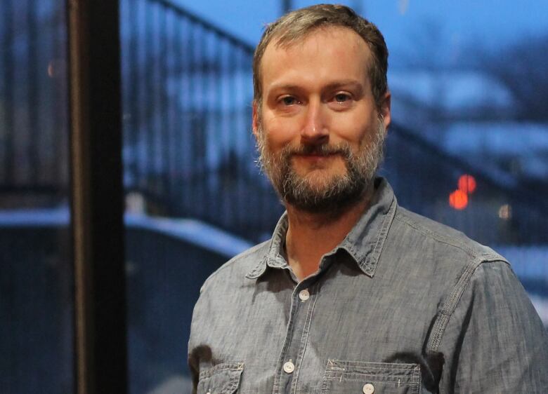 Man with beard wearing a grey dress shirt