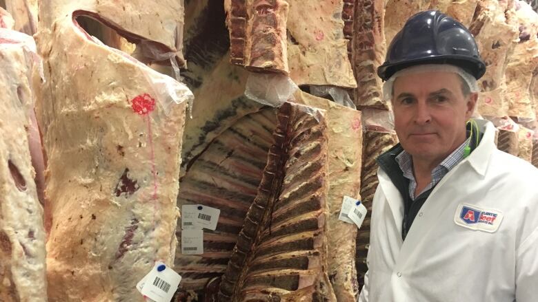 A man with safety gear on a meat processing plant.