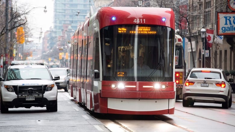 A red streetcar driving on the street.