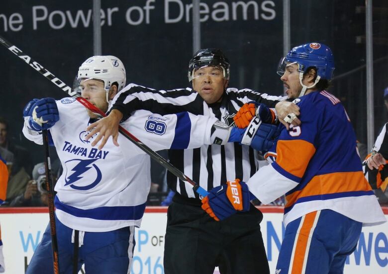 Jay Sharrers is seen on the ice breaking up a fight between Tampa Bay Lightning and New York Islanders players.