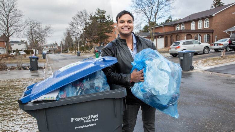 Portrait of a man putting trash in a garbage can.