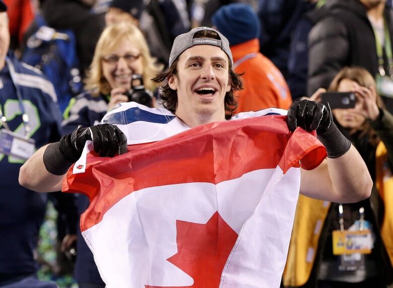 Luke Willson holds up a Canadian flag after the NFL Super Bowl XLVIII football game against the Denver Broncos, Sunday, Feb. 2, 2014, in East Rutherford, N.J. The Seahawks won 43-8.