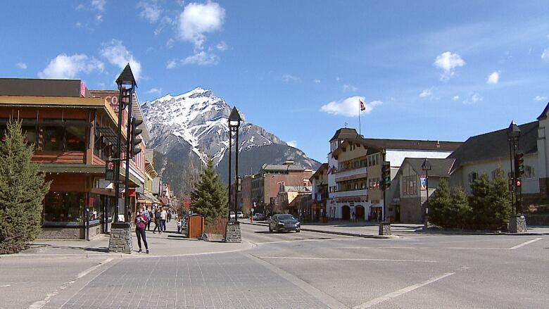 A street view of the town of Banff. A large mountain can be seen in the background. 