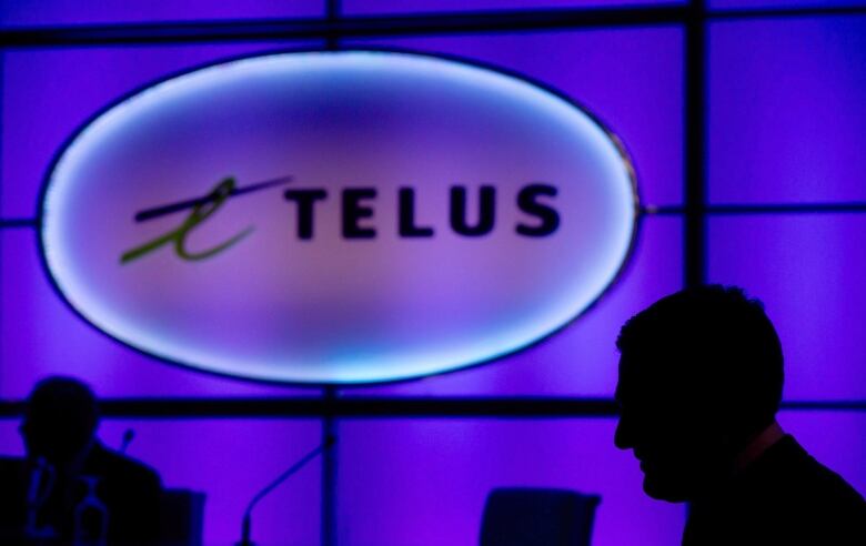 The Telus logo is silhouetted against a purple background.  