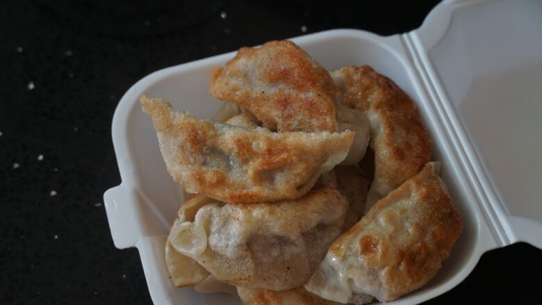 Fried dumplings in a Styrofoam container.