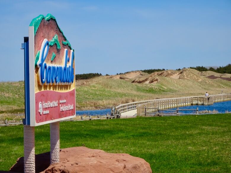 A sign saying Cavendish with sand dunes in the background.