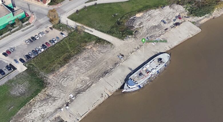 An aerial photo shows a boat docked at a wharf.