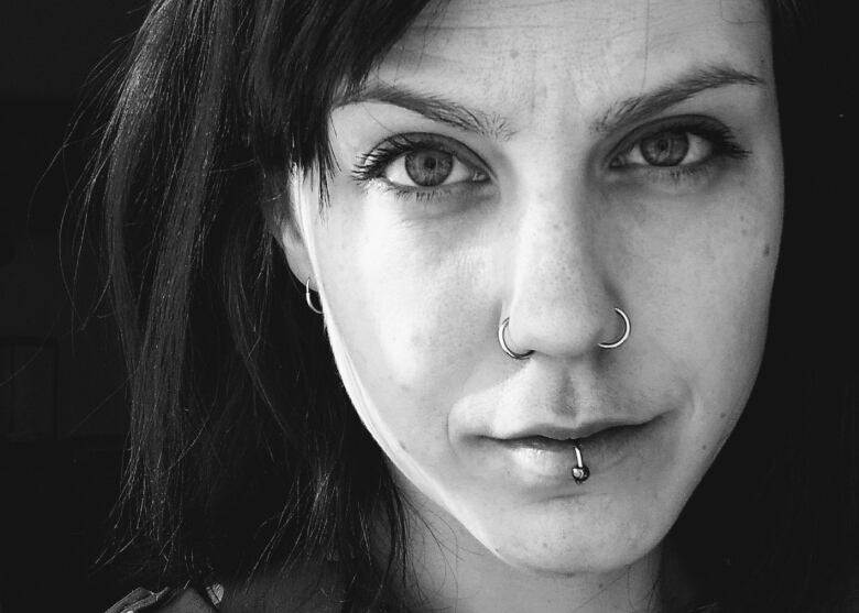 A black and white picture of a person with a lip piercing.