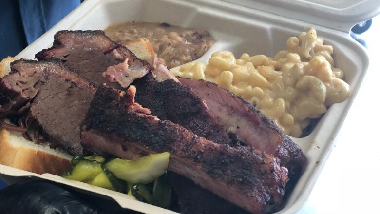 A close-up of meat in a takeout container