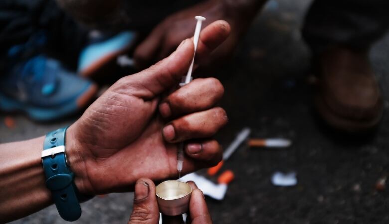 NEW YORK, NY - OCTOBER 07:  A heroin user prepares to shoot up on the street in a South Bronx neighborhood which has the highest rate of heroin-involved overdose deaths in the city on October 7, 2017 in New York City. Like Staten Island, parts of the Bronx are experiencing an epidemic in drug use, especially heroin and other opioid based drugs. More than 1,370 New Yorkers died from overdoses in 2016, the majority of those deaths involved opioids. According to the Deputy Attorney General, drug overdoses are now the leading cause of death for Americans under the age of 50.  (Photo by Spencer Platt/Getty Images)