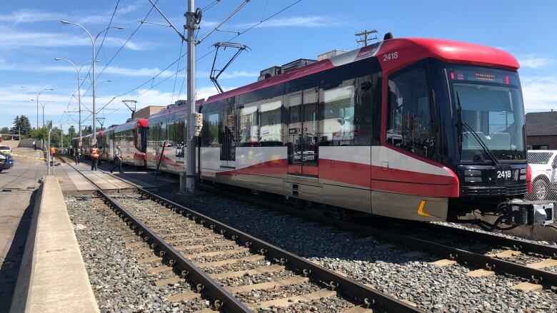 a train is pictured on the tracks. the sky is blue and it is sunny.