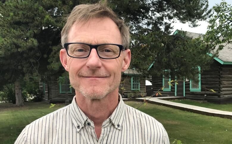 A close-up of a smiling white man with glasses.