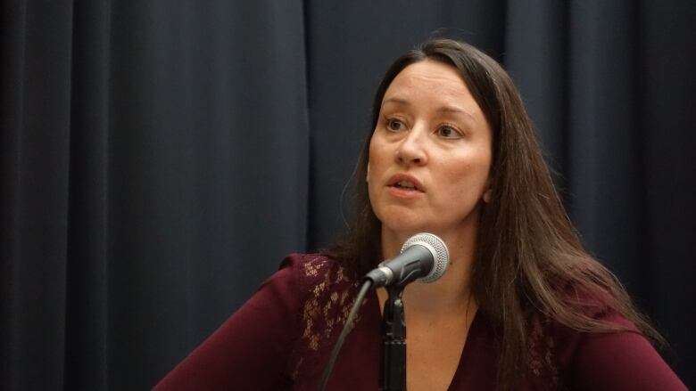 Picture shows a woman in front of a microphone. 