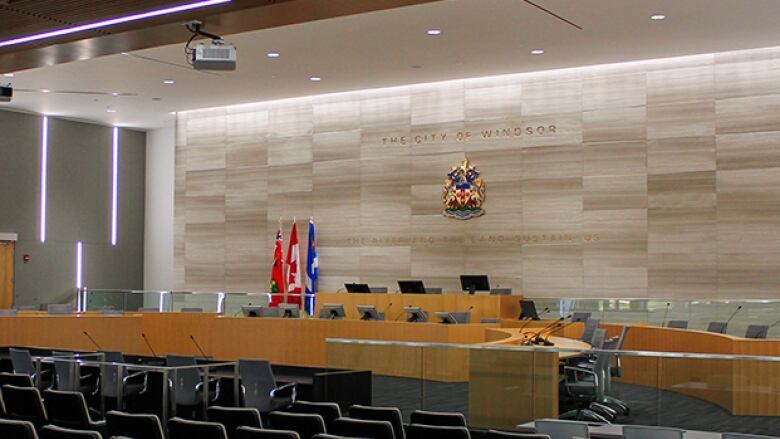 An empty room with chairs and seats for councillors at the front.