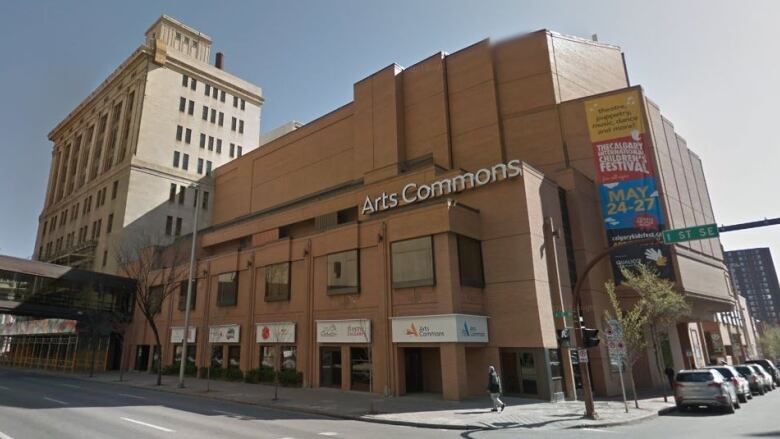 A low-rise building downtown is seen in daylight with a sign that reads 