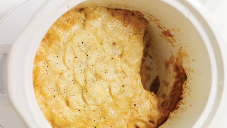 Overhead shot of a slow cooker filled with scalloped potatoes.