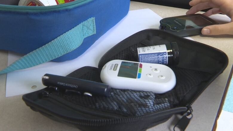 A glucometer in a black case.