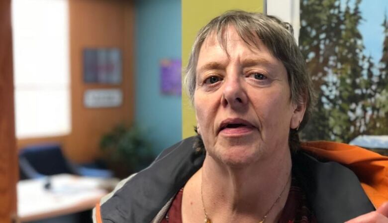 A woman stands in an office.