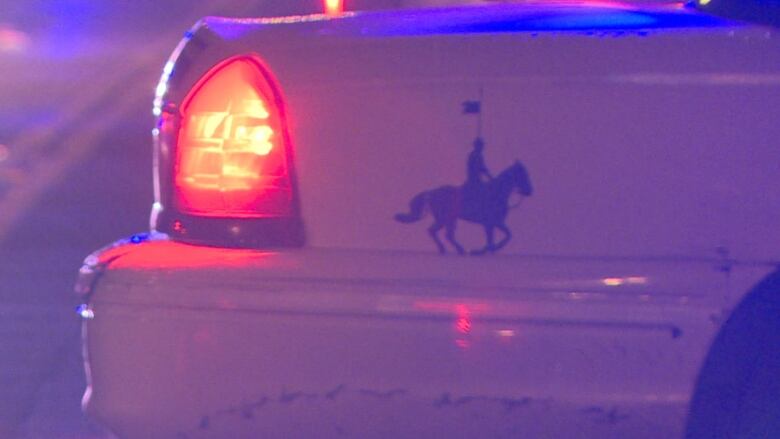 The back of a police car, with clip art of a Mountie on a horse.