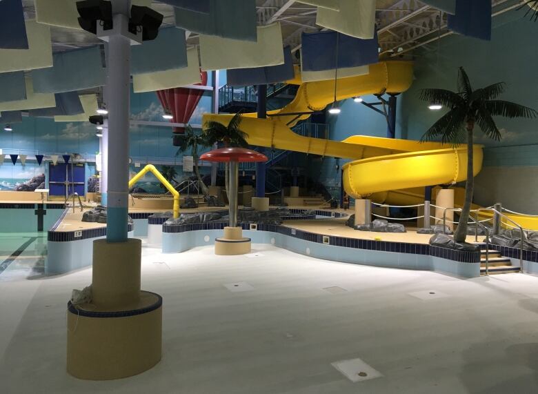 An empty indoor pool with slides.