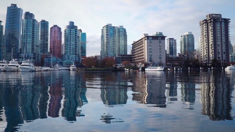 Numerous skyscrapers around Vancouver's Coal Harbour reflect in the water.