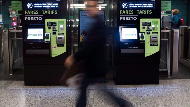 People walk past Presto machines underground in the TTC subway portals in Toronto. 