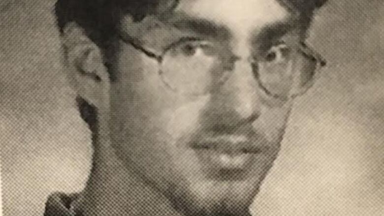 In a black and white headshot, Steve Wright has hair parted down the middle, a mustache and goatee and is wearing glasses. 