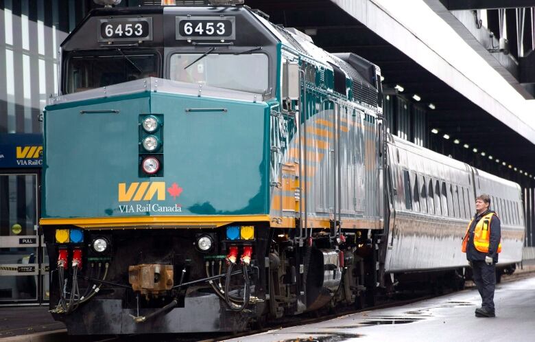 A VIA Rail employee stands on the platform next to a F40 locomotive at the train station in Ottawa on December 3, 2012. 