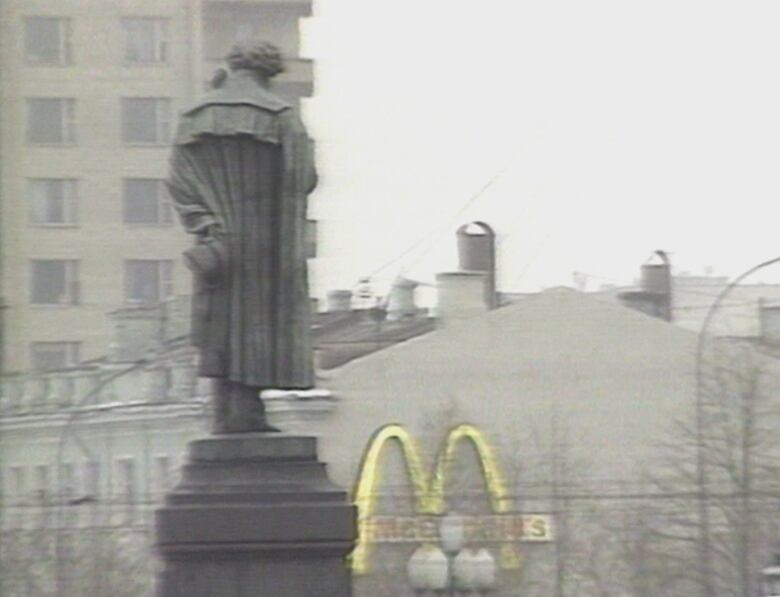 Statue next to Golden Arches logo 