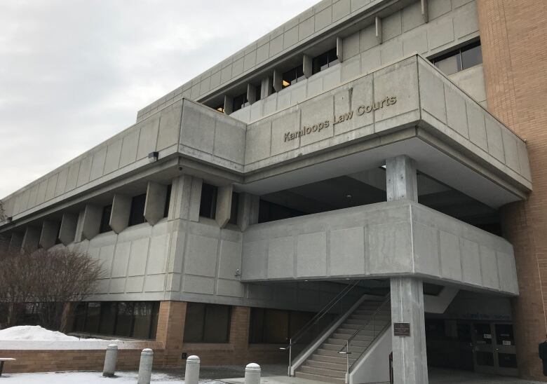 An image of a blocky white building. Lettering reads 'Kamloops Law Courts'.