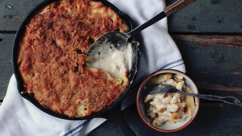 A cast iron skillet with mac and cheese in it. 