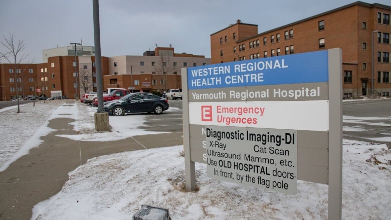 A sign in front of the Yarmouth Regional Hospital with the hospital building in the background.