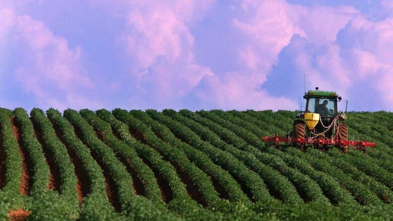 A tractor in front of a colourful sky